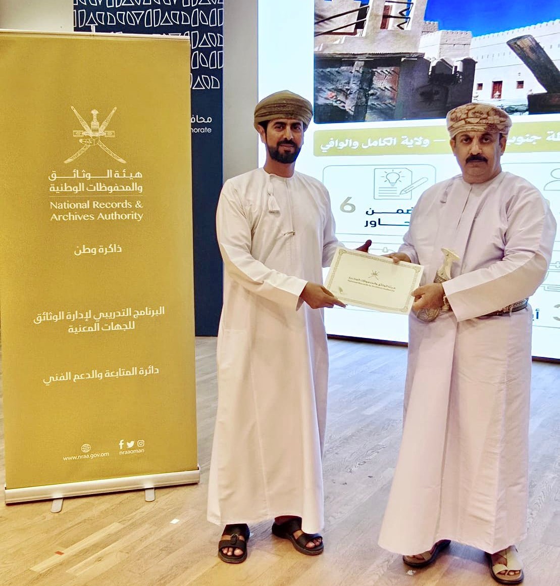 تظهر في الصور والي الكامل والوافي يقوم بتكريم إحد المشاركين في البرنامج التدريبي